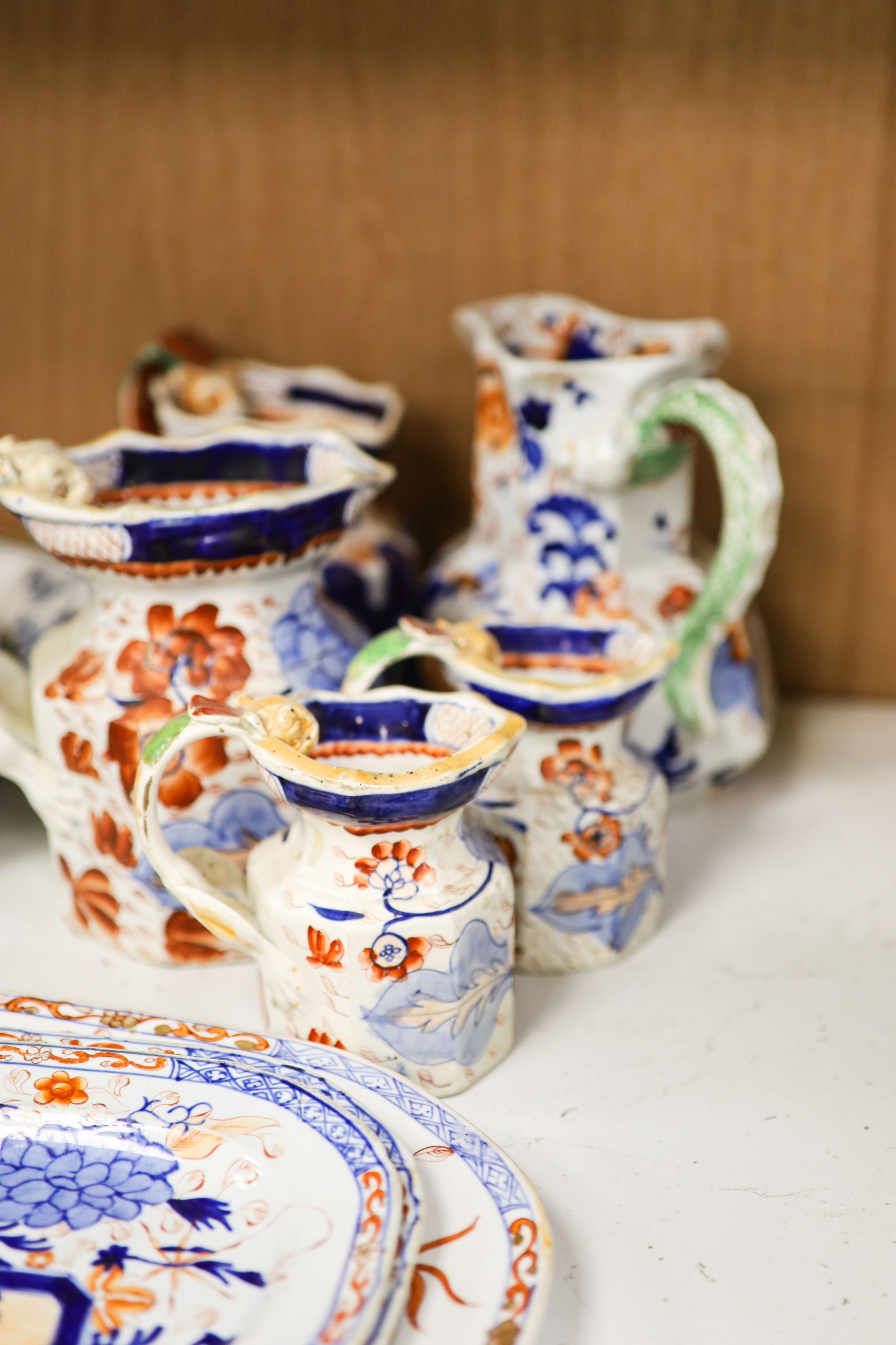 Nine pieces of Victorian Masons Ironstone, five Hydra jugs, a Delft charger and relief moulded teapot.